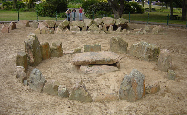 Ville ès Nouaux which consisits of a Cist-in-circle and a Gallery grave on the outskirts of St Helier. Situated in St Andrews Park a fenced off circular area contains two tombs; the first is a gallery grave which is 11.5m long, 1.2m wide and lm high. Seven capstones are in place on the roof, but unfortunately two were lost in the 19th century when sand that covered it was excavated. Damage had al