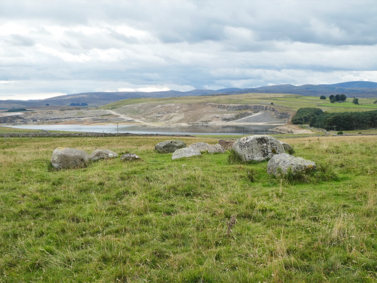 A small circle of large boulders, with a few more in the centre which may once have formed a cist.  
