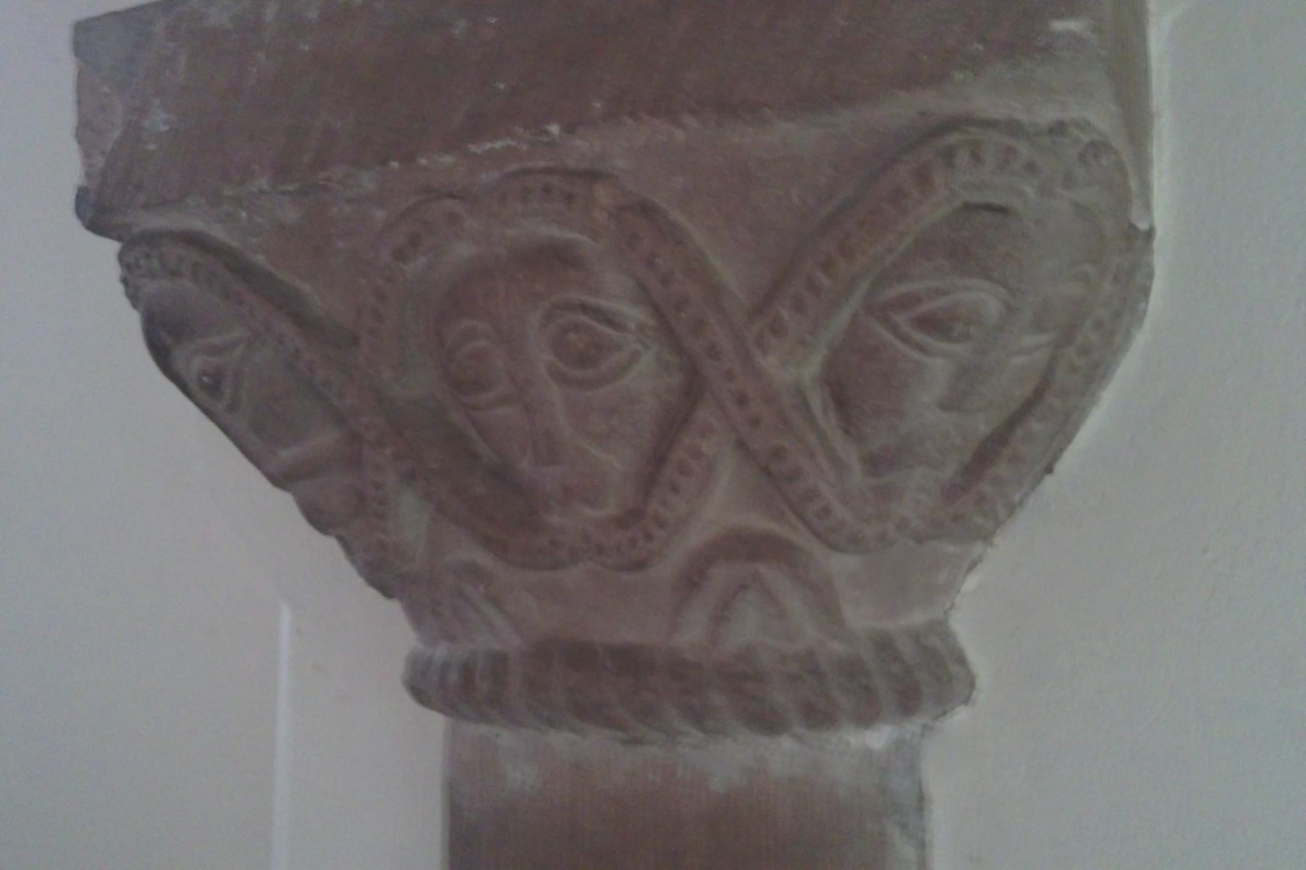 Carved heads, photo taken in 2011
There may have been a church here before the 10th century. The church you see today was begun in the 12th century. It lost its thatched roof in the 18th century, and one of the crosses turned into a sundial.
