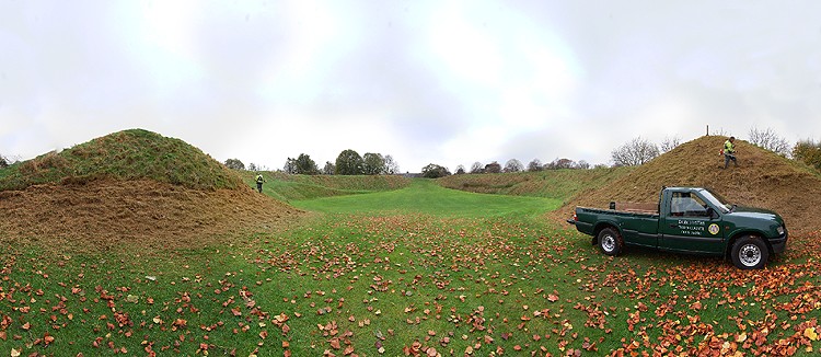 The entrance to Maumbury Rings. 
The Neolithic Henge in the middle of Dorchester has been used as a Roman Amphitheatre and during the Civil War as a defensive artillary base.
The men in the picture are strimming the banks for Dorchester Council.