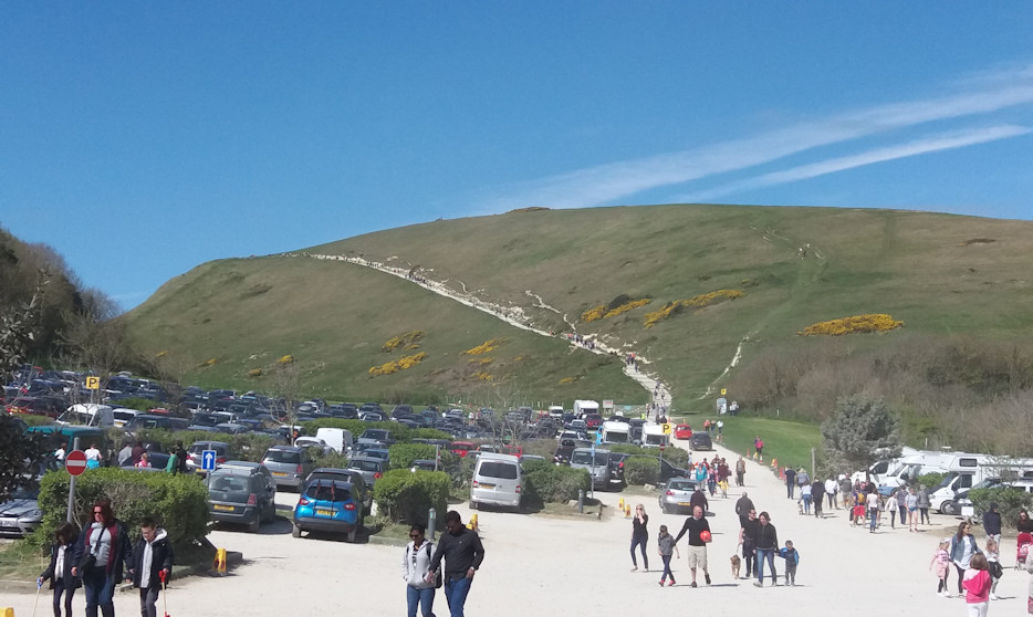 View  of Hambury Tout Hill, from the car park at Lulworth Cove, Easter 2017. 

There are a couple of barrows on top of Hambury Tout, near the busy coast path on top of the steep hill between Lulworth Cove and Durdle Dor.  Absolutely beautiful here, but can get very crowded, and was on a sunny Good Friday.
