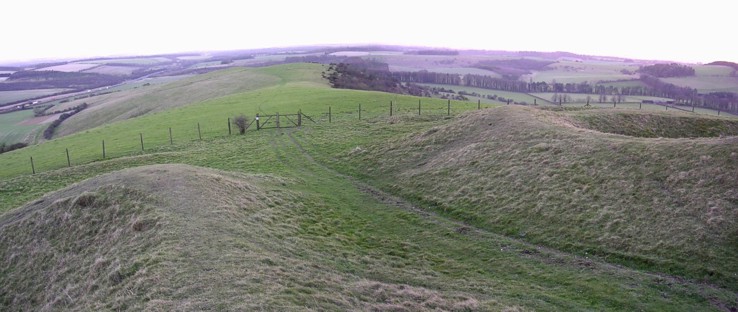 February 2005. Composite image of the entrance to Beacon Hill camp, looking out along the chalk ridge (private grazing land). The ends of both banks and the ditch are in-turned, and there are also slight outworks. The present-day visitor access is to the opposite corner of the hillfort, up a ridiculously steep slope from the car park.