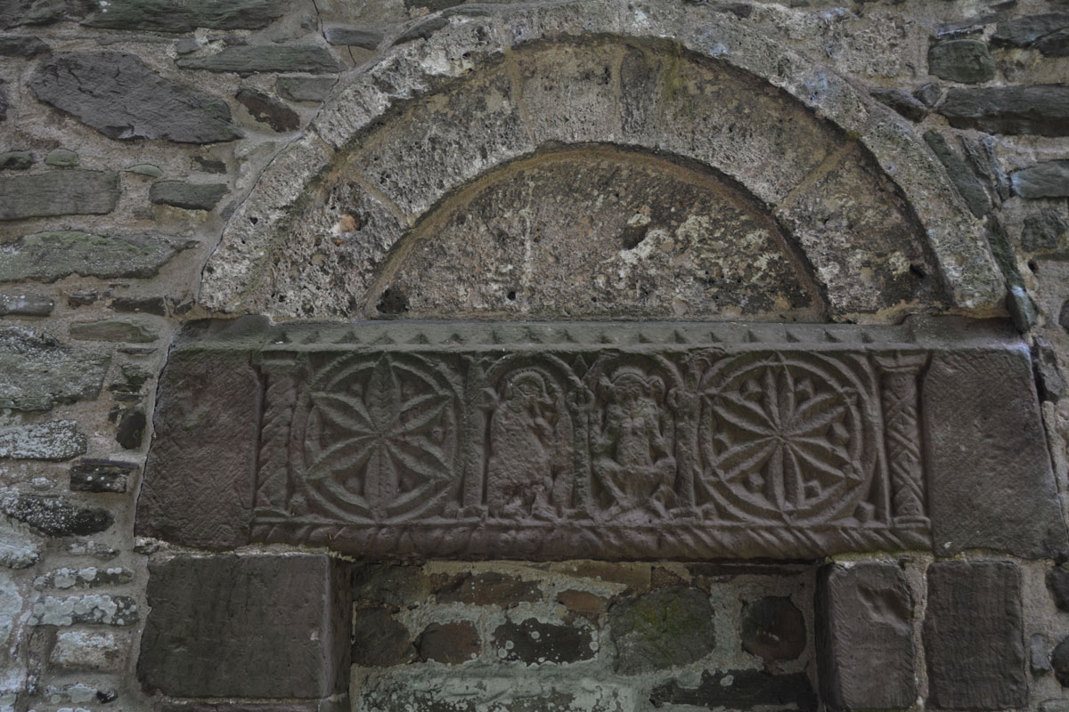 The blocked exterior north door with its intricate carvings on the lintel, which include 