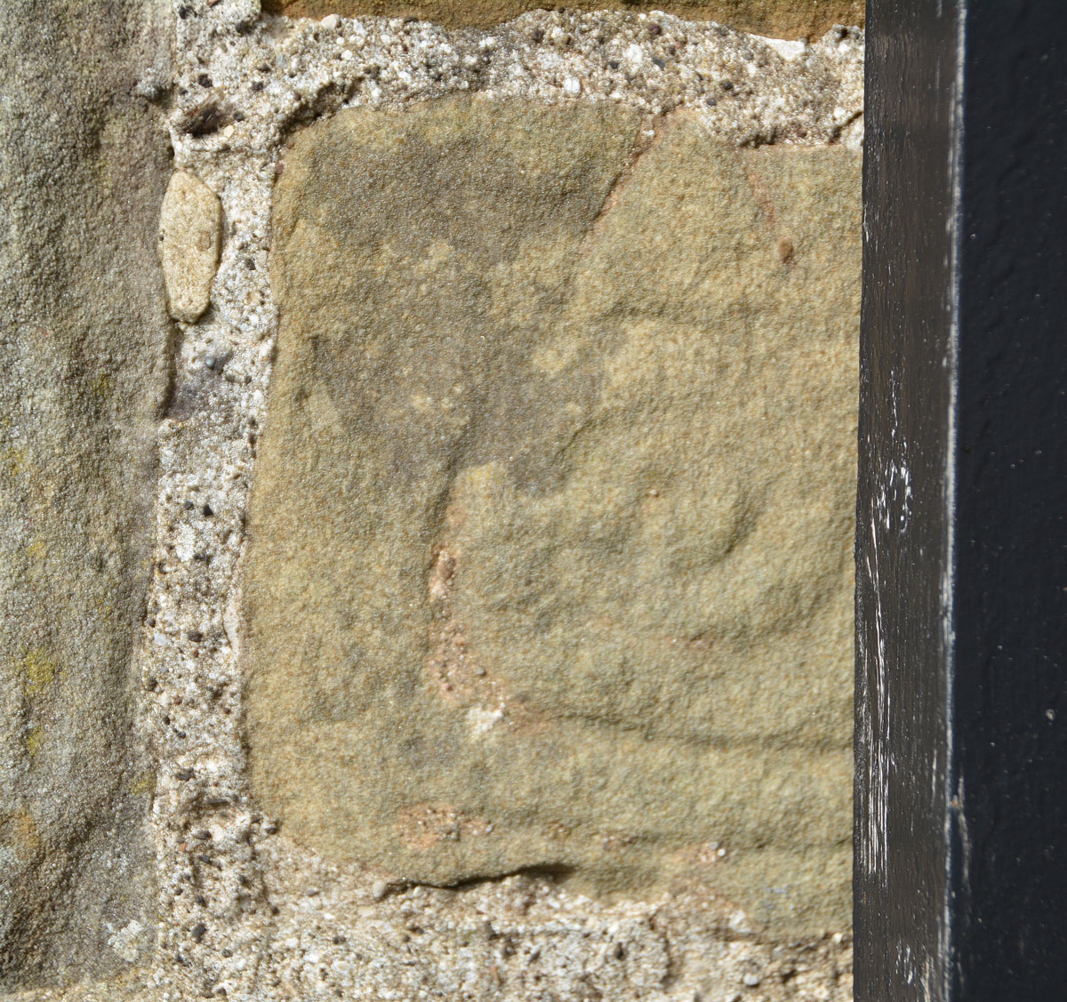 This fragment is dated from the late ninth to mid tenth century, and can be found built into the exterior eastern wall of the nave, near its junction with the south wall of the chancel.  It is partly concealed by a large, modern drainpipe. It is recorded as AS Corpus Kirklevington 22, and shows (on the left hand side) part of a broad edge moulding which curves at the top and with 