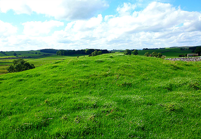 The grassy tumulus (round barrow) on the side of Lower Colgarth Hill, near Bell Busk, North Yorkshire.