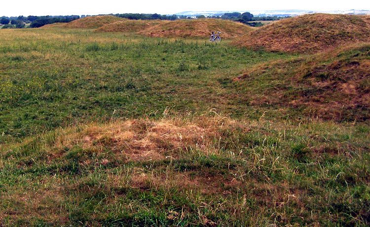 This is the Ashen Hill Barrows, taken from the top of the first one from the East.
Taken on the 30th of June 2010, the very dry weather has dried out the ground, turning the grass on the Barrows brown and making them stand out against the rest of the field.
