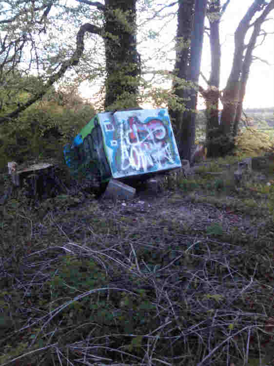 The top of the barrow. Talking to a local resident the area is frequented by youths who use it as a drinking den. The artwork would point towards that being true.