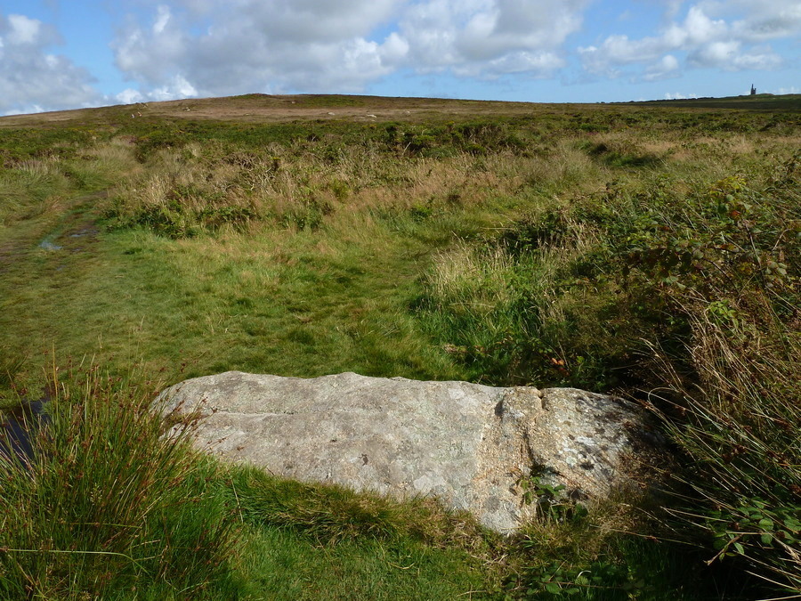Four Parishes Rock, I believe the right hand side of this stone is a slightly different colour because it was once in the ground (for a long time), therefore making this a former Standing Stone. The weathering at the other end (left) is also going in the right direction if made when stood up. Ding Dong mine is visible on the right.