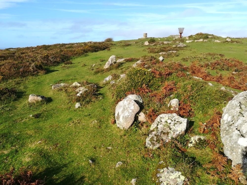 Showing some of the Kerbstones at Carn Brea Neolithic long cairn SW38572798, You can clearly see the mound of another cairn just to the right of the Beacon Post, It has a large possible capstone on it
