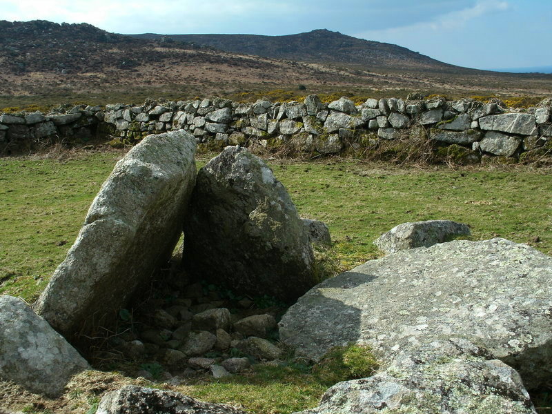 A close up of the ruined chamber at Bosporthennis Quoit looking over to Hannibal's carn and Carn Galver behind.