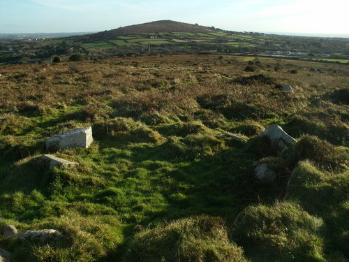 A hut circle on Godolphin Hill with Castle Pencaire in the background, it has great views all around.