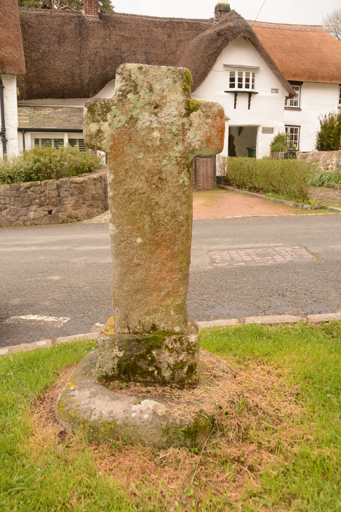 The North Bovey cross, trying to show how the hole in the socket stone is different in shape from the cross which now occupies it. The socket stone is said to be from the original village cross, now in pieces and probably built into a wall of the cottage opposite (Stone Cross cottage).
