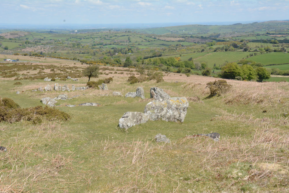 Standing at the top of the hill looking down the line of the four most prominent hut circles.  The view point car park at SX 69834 83454 can be seen just above middle/centre at the left hand side of the photo. Butler (Volume 1, p162) says that 