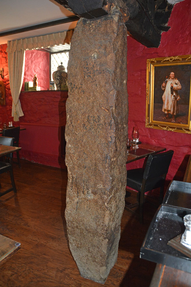 According to the barman, this is a Roman pillar, reused to prop up the roof of the dining room. Haven't been able to find out much about this stone, but will try.