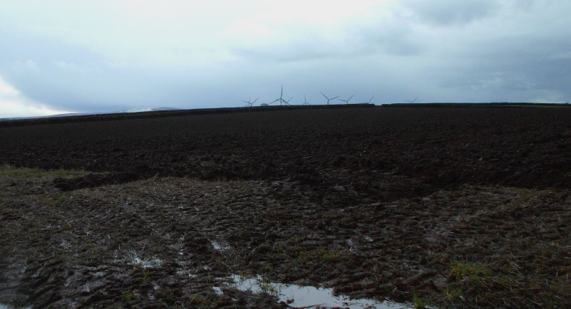 View from gateway of henge field, looking diagonally across it towards the site of the henge, overshadowed now by several huge wind turbines at Den Brook wind farm. They became operational in October 2016, despite the efforts of local groups who hoped to prevent the spoiling of the valley and this monument's ambience.
Sorry about the state of this photo, but the weather was poor and there is snow