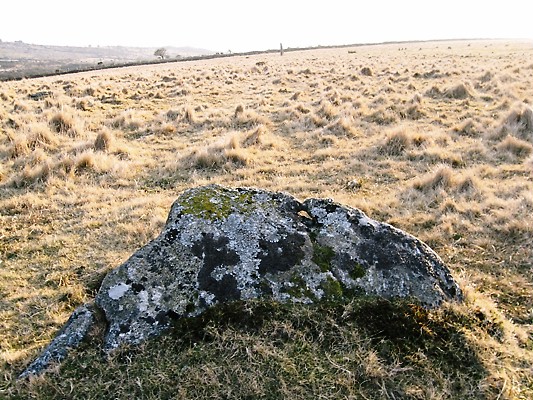 Slab 1 with the hole in it, here looking towards the SW and the standing stone in the distance.
(A separate photo will show the hole in close-up).
Jack Walker says that this hole and the menhir align with the place on the horizon where the winter solstice sun sets.  He wonders if this is the original Winter solstice sunset alignment at Merrivale.