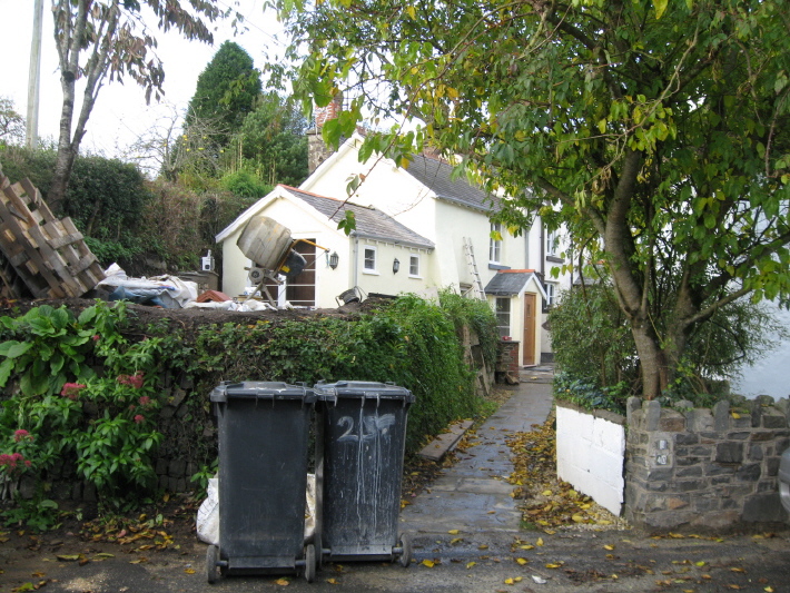Walking east past the church (which is at the top of a sloping, cobbled square), and the pub, look out for this turning on your left.  Hard to see with the bins there, but without asking someone, I'd never have found it.  (Luckily it was the builder working on the neighbouring cottages!!)