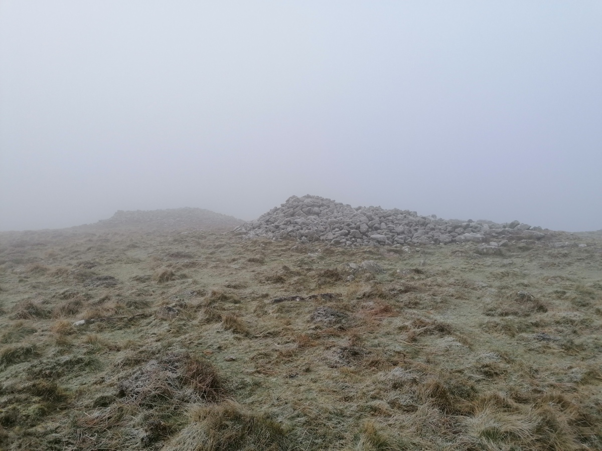 Rippon Tor cairn C5 with C4 beyond, in the freezing fog of a December day