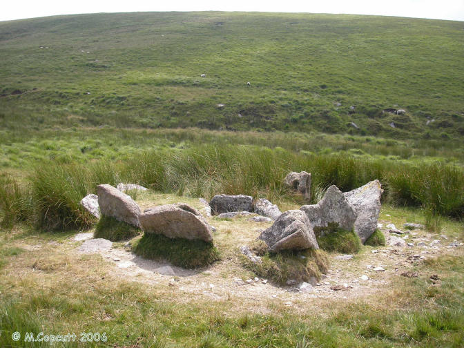 What a lovely find this is, miles from anywhere across the middle of Southern Dartmoor, and well worth a visit. 

This cairn is surrounded by 9 large upright slabs making a full circle, some of which are over a metre in height. In the centre is a large rectangular kist, about 1.5 by 1 metre, and almost 1 metre deep