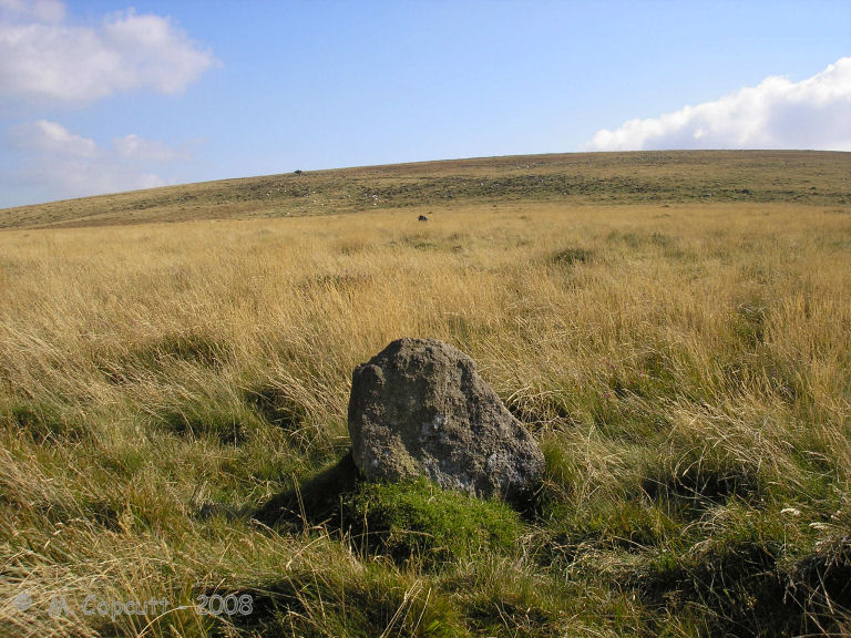 View east over the possible Sticklepath stone circle, on the slopes of Cosdon Hill. 
In the foreground, the prominent stone I first found several years ago, while in the middle distance my bag marks a stone at the southeastern side, seen as a dark blob in the sea of long grass. 