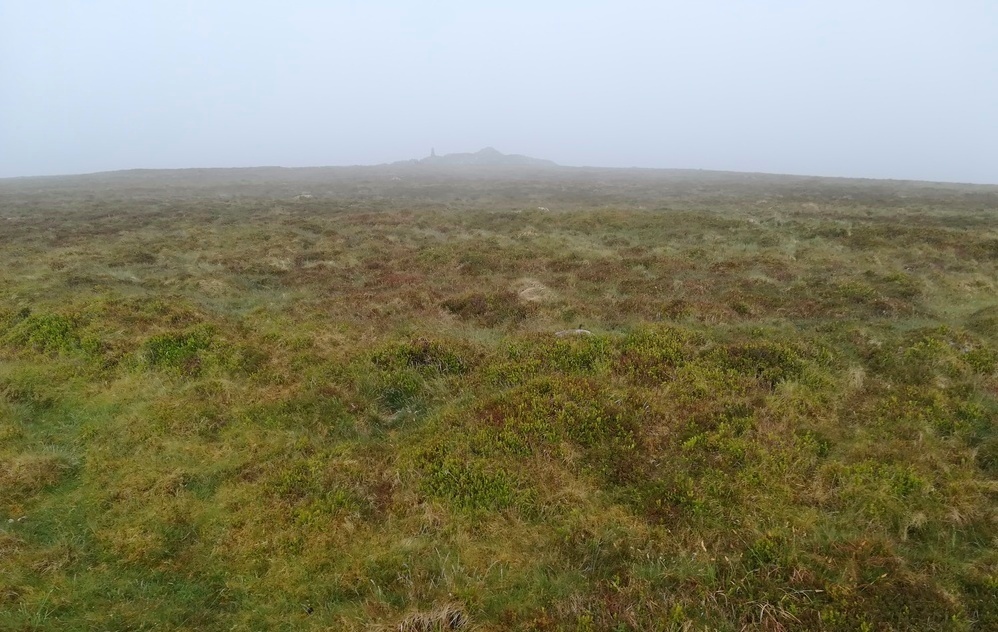 Cosdon Hill Summit Cairns, The Northern Ringcairn with the main summit Cairn in the misty background