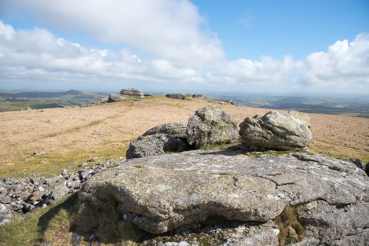 View from the west, illustrating the position of propped stone on top of the granite outcrop which makes up the central area of the cairn. 