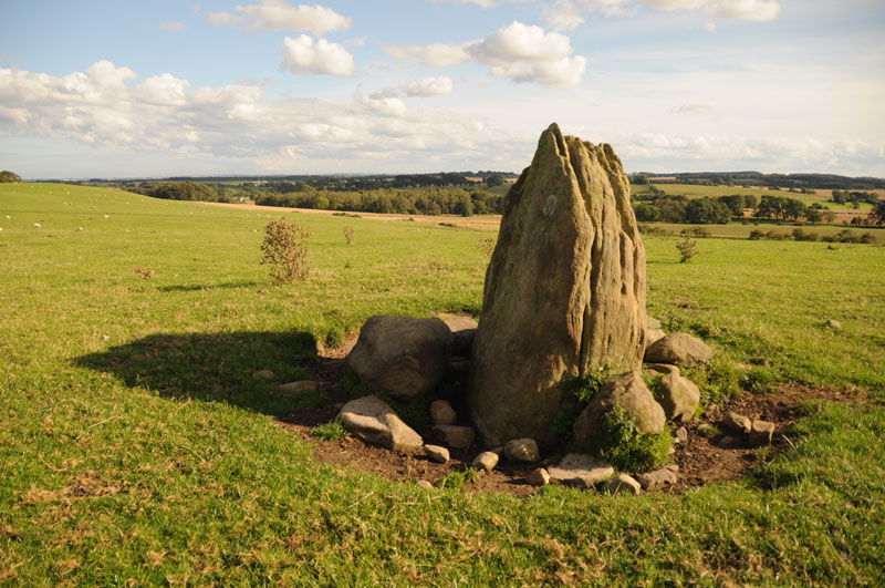 Standing between the tumulus (out of shot to the left), looking south eastwards, with the northern and western faces of the standing stone prominent in the image.
