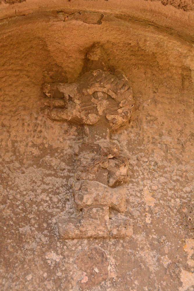 The rather gruesome carving of a dragon's head impaled by a sword, can be found on the back wall of the structure, above the spout plate and just below the top arch. 