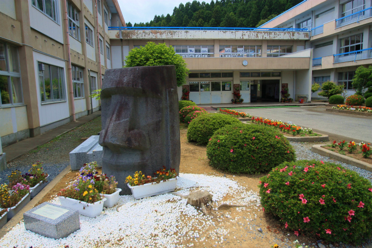 

Site in Honshū Japan

The rescued head of the 1st Moai in the playground of Shizukawa High School (38.68127N,141.43903E) which was used as the evacuated camp for the tsunami victims for a few months and the temporary houses for the residents 
still stand in. 
Please note the message which the students put on the windows behind : 