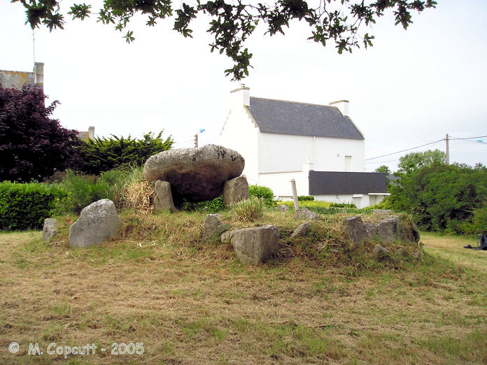 The Dolmen de Menez-Veil can be found right by the roadside near a roundabout at the entrance to the village of Lesconil, on a little tended grassy area. 

It looks like it might be somebodies garden. 
