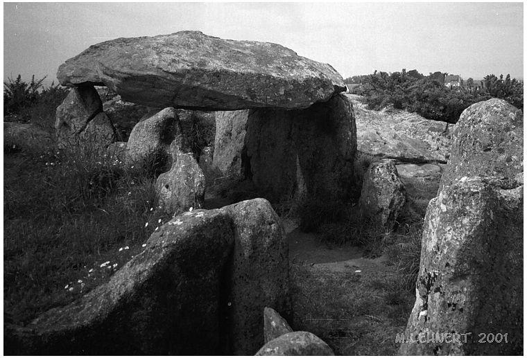 Site in Bretagne: Finistère (29): Standing a the south-eastern end of the chamber beside the entrance. Looking towards NW.
Foreground centre left:  passage orthostat.  The upper parts of the entrance stone and another passage orthostat visible at central lower edge of picture (May 2001)
