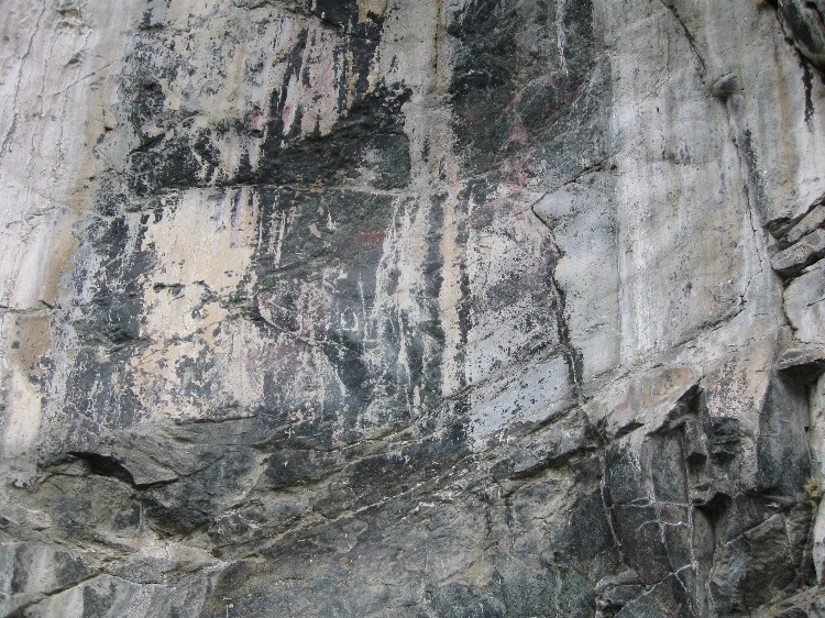 The use of a cleft in the rock face to enhance the outline of the head of a deer painted in red ochre