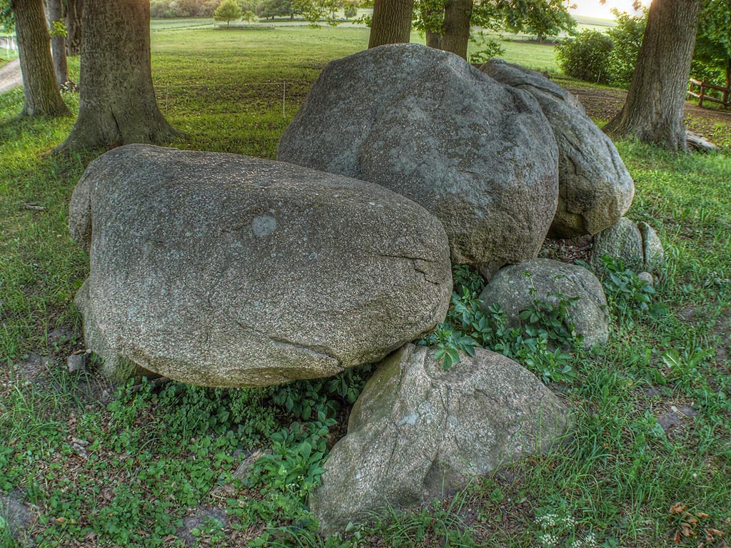 Chambered Tomb in Mecklenburg-Western Pomerania

Well preserved stone chamber, oriented North-South.
Three uprights on the east long side; two on the west
long side, here is one missing.
Chambers size 3.8m x 1.5m.
Three capstones, one of them broken into pieces.
We see some cupmarks on two of the capstones.

This is a very nice location, right behind the castle Basedow. 