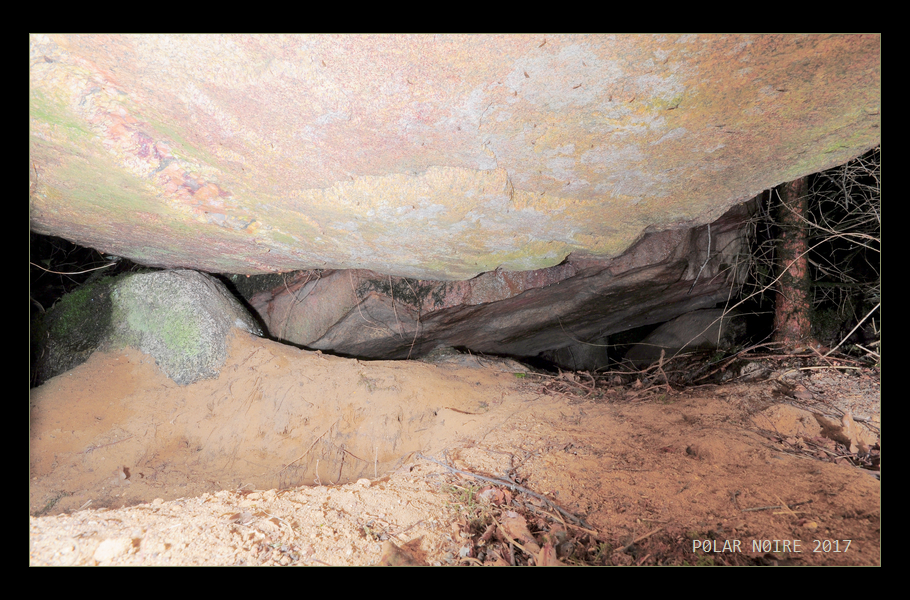 View inside the passage grave chamber with help of remote flashlights. Chamber is largely filled with earth of the eroded barrow, but in general well preserved.  Mostly beautiful reddish granite has been used for the chamber as can be seen here. On the outside it is hard to make out due to moss and lichen.  August 2017