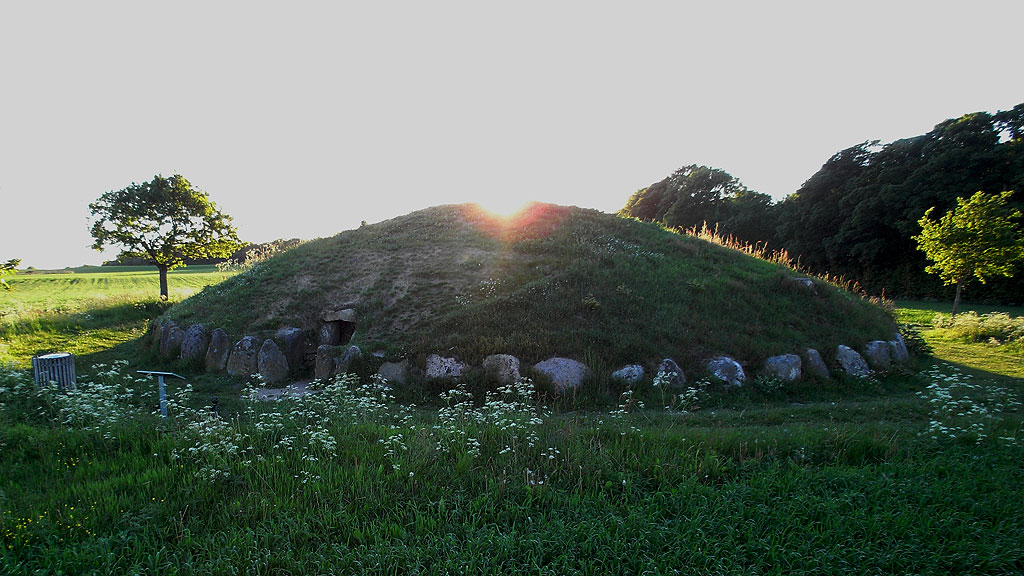 Round Barrow with enclosed Passage Grave 'Grønhøj', 1940 excavated and restored.
The mound measures approx. 20 m in diameter and is approx. 2.75 m high.
There is a passage inside from the mounds southeast side.
The chamber measures approx. 3.50 x 2.75 m and is 1.5 to 1.7 m high,
set of 8 carrying stones and covered with 2 capstones.
Passage, which measures approx. 4 x 1 m and is about 1 m h