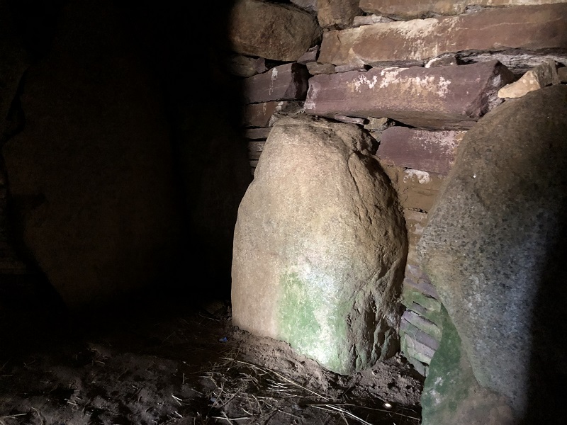 The sun light shining through the northern passage and onto the stones in the back of the chamber opposite the passage. 