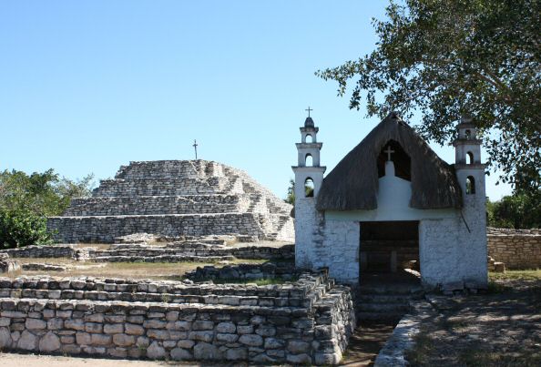 A small church at the site, next to the main pyramid which has a cross perched on top of it.