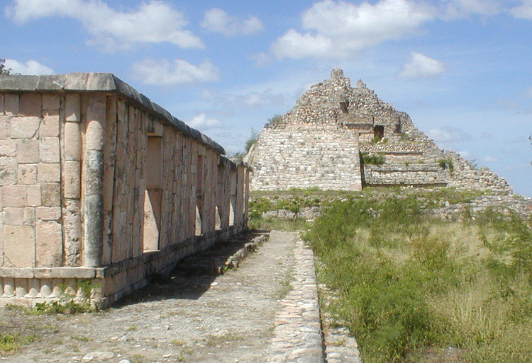 Structure MA-9 with the pyramid in the background.Building MA-9 bounds the north part of the Southeast Plaza of the Ah May Group. Its principal facade, which look to the north, extends out excessively because a large open esplanade, constituting the Northeast Plaza, was found in front of it.Building MA-9 is a palace-type and was built during the Terminal Classic period (750-1050 A.D.), final era o