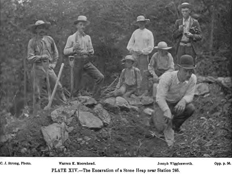 One man working, six looking on, all in period hats, old image from 