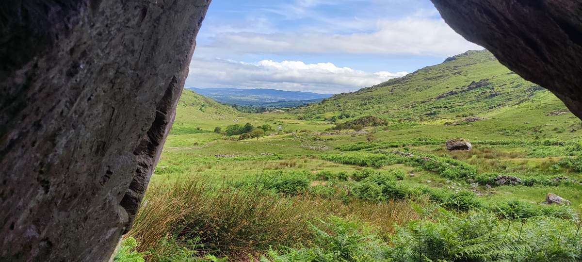 Looking south down the valley from the cave opening.

The cashel ringfort  is visible straight ahead.

Photo taken June 2023.