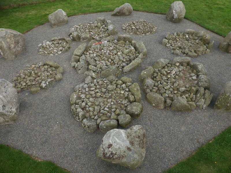The kerbed cairns in the centre of the stone circle.  View from above and west.