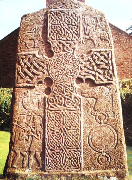 Another view of The Glamis Manse 2 Stone. The carved slab with its Pictish cross, warriors, animal head and horsemen, dates from the 8th century, though the stone itself pre-dates Christianity. Obviously it was put to good use by early Christians. On the reverse are cup-marks, more horsemen, strange animals and a Z-rod.