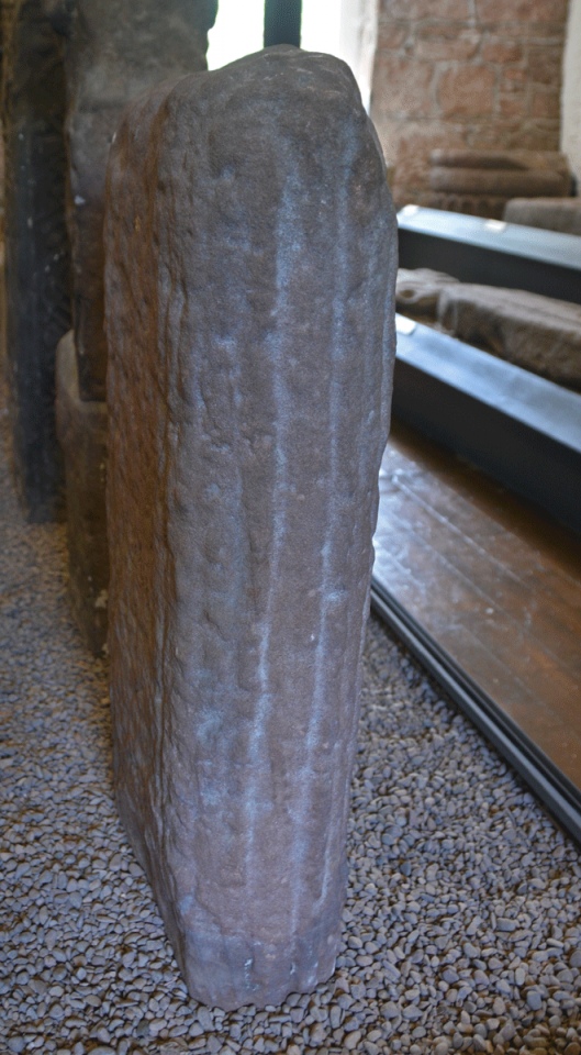 Standing to the right of this cross shaft fragment (stairs behind), showing the roll moulding and rounded edges of this piece. Recorded also in Guy Points' Dumfriesshire Gazetteer, page 170.