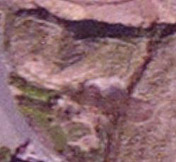 satellite view showing half the wall circuits surviving, with the cliff-face marking the entrance axis