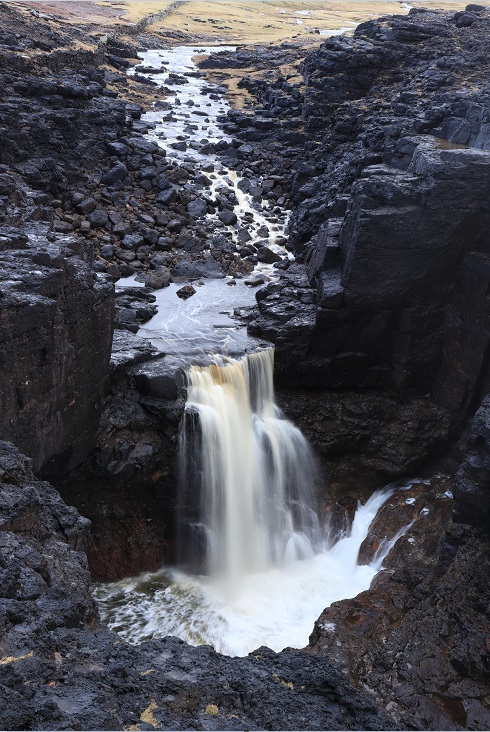 Warie Gill in the North West Mainland.

Shetland's own little piece of Iceland - black lava and a waterfall.

It can fall up to 60ft depending on the tide.

HU 23959 83285
