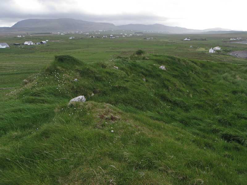 Grassy ramparts on the west of Dun Bornaskitaig, probably obscuring several courses of walling. 