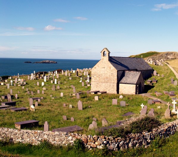 St Patrick's Church and churchyard at Llanbadrig, Anglesey. A nice view looking beyond the graves towards the sea at Ynys Badrig, where the Irish saint was shipwrecked in the 5th century. Some historians believe the Patrick who came here was a 6th century monk at Caer Gybi, Holyhead. He was said to have visited St Columba at Iona.