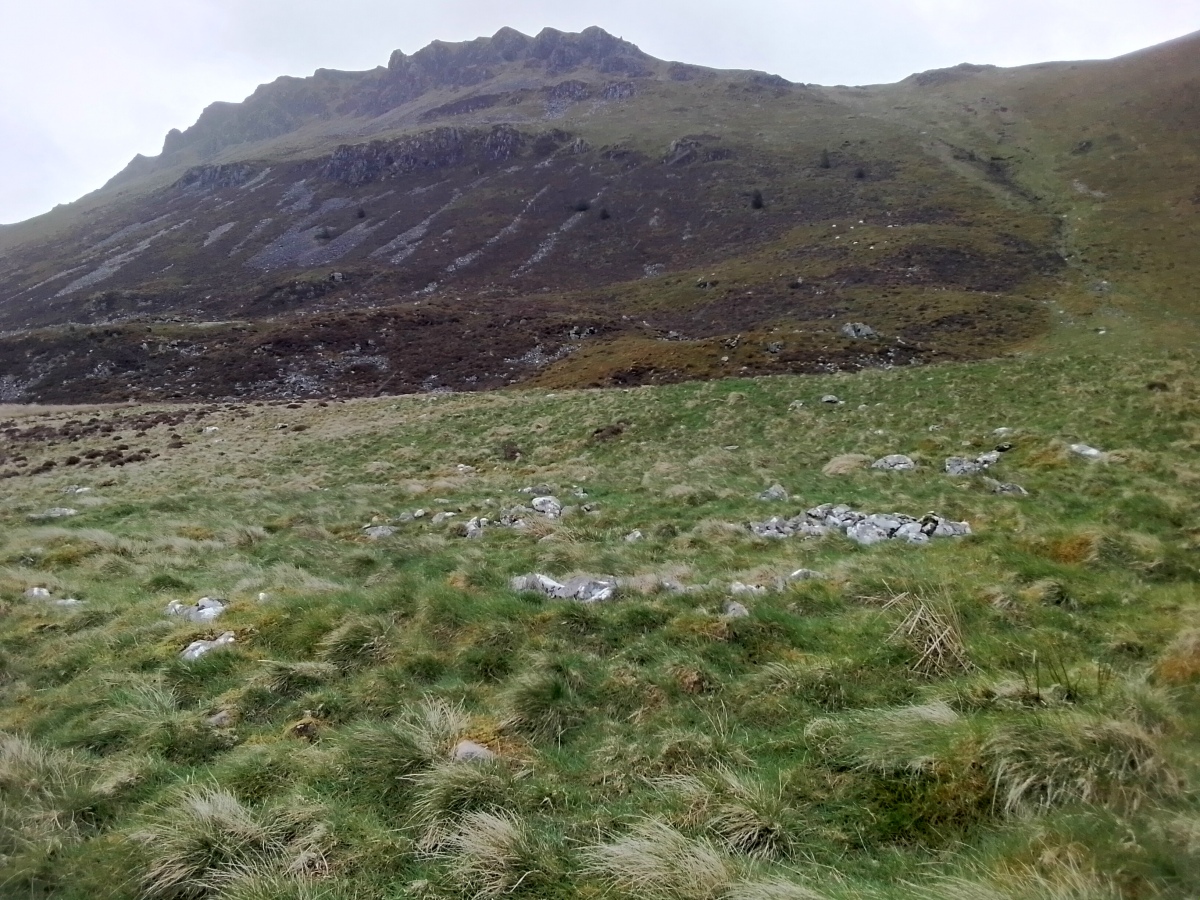 View to the east across the 5m diameter hut  (centre) with Tyrrau Mawr towering above. 