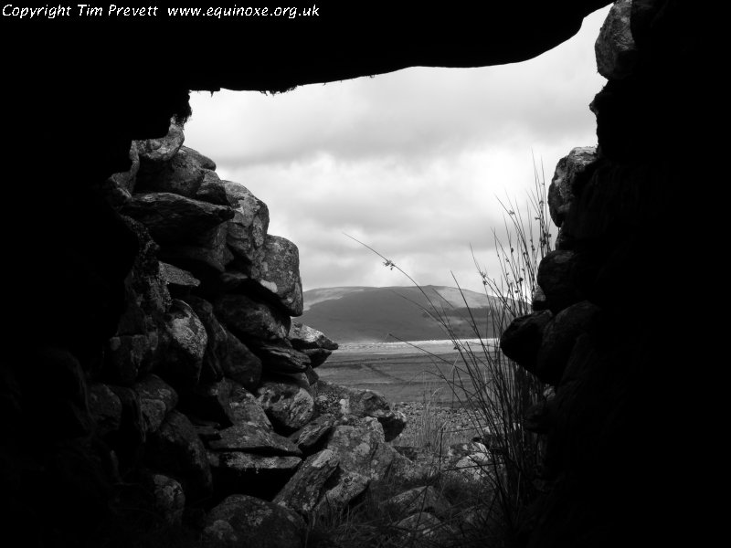 Looking out of the later chamber of the southern cairn, to the north and the dominating domed headland of Moelfre.