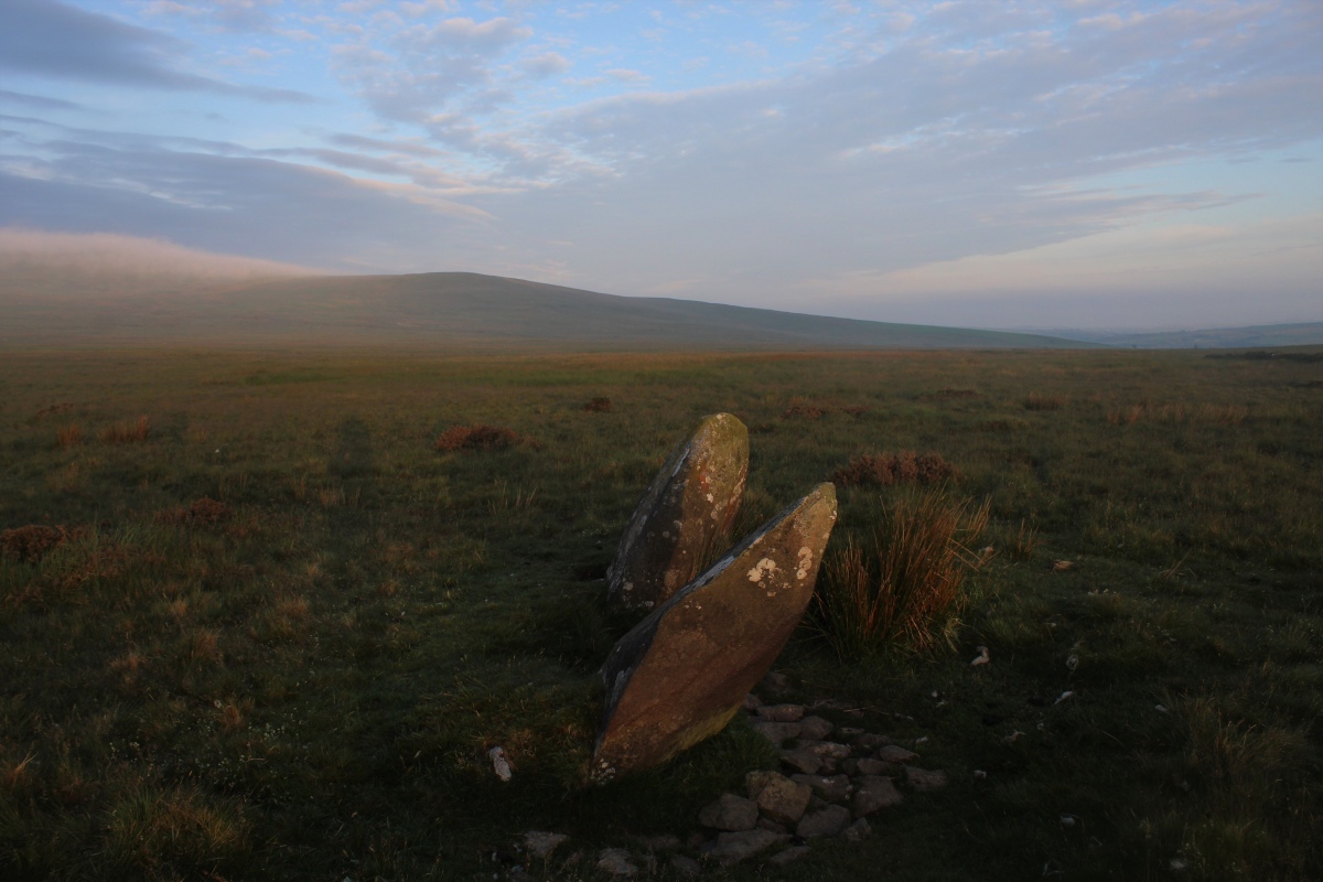 Pair of standing stones with cloud on the hills and a tall shadow creature that seems to be mimicking me.